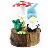 Gnome sur socle en bois avec champignon rouge